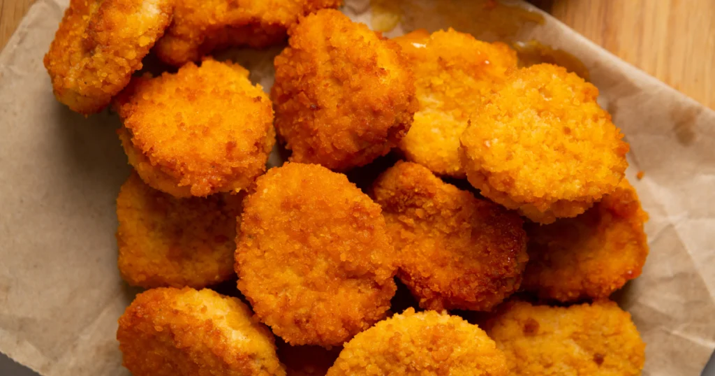 chicken nuggets on a colorful plate with dipping sauces.