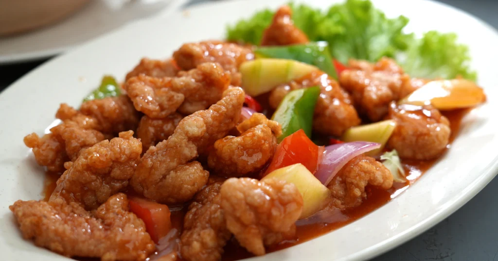 sweet and sour chicken featuring golden-brown chicken pieces coated in a glossy sweet and tangy sauce.